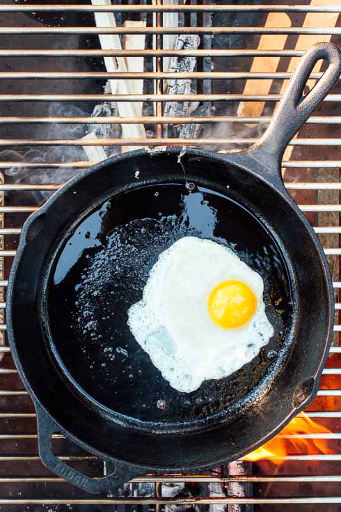 Sunny side egg in a cast iron skillet over a campfire