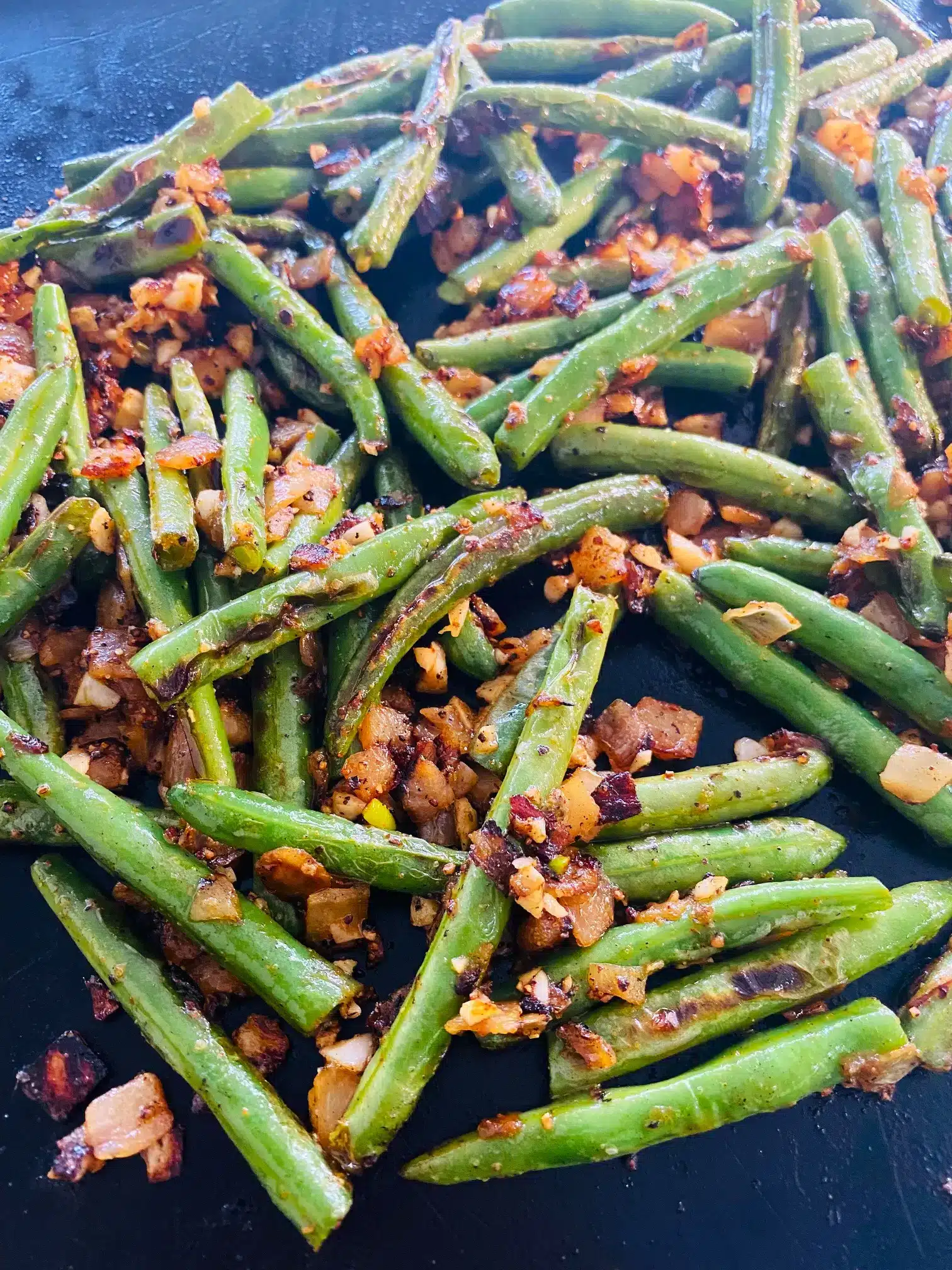 Green beans cooking on a griddle.