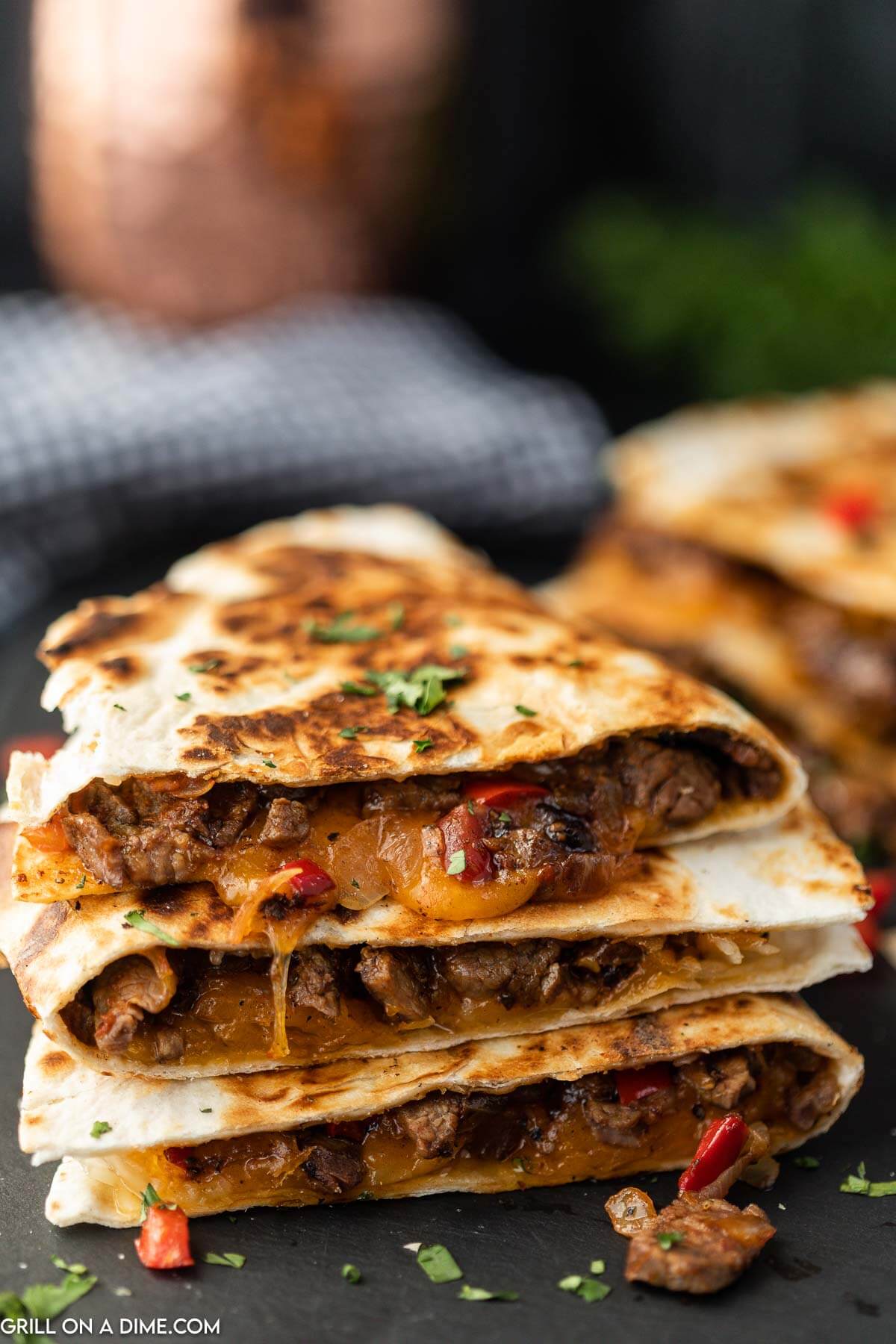 Steak quesadilla wedges stacked on a plate.
