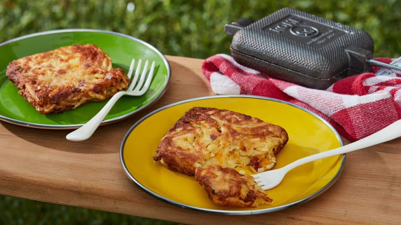 Hash browns cooked in a square pie iron on plates.