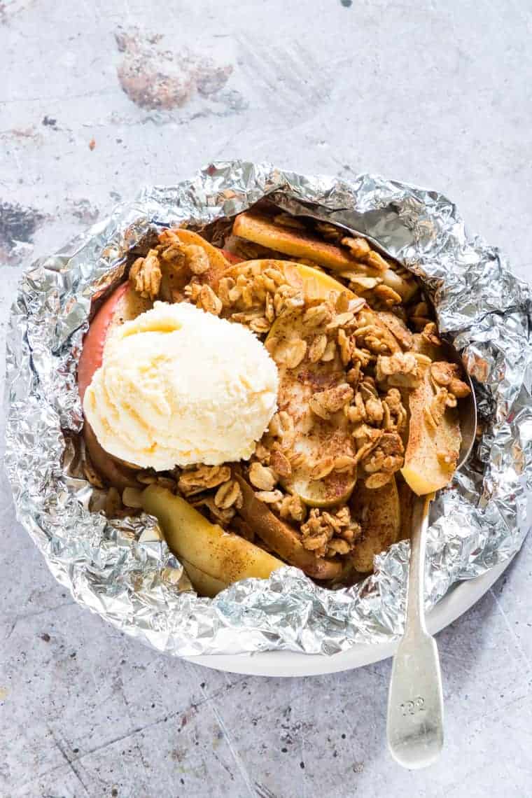 Apple crisp topped with ice cream in foil.
