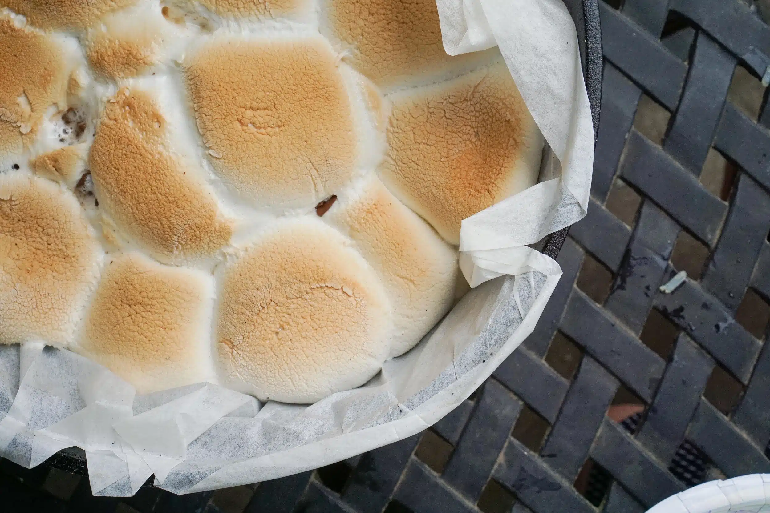 S'mores cake in a dutch oven lined with parchment paper.