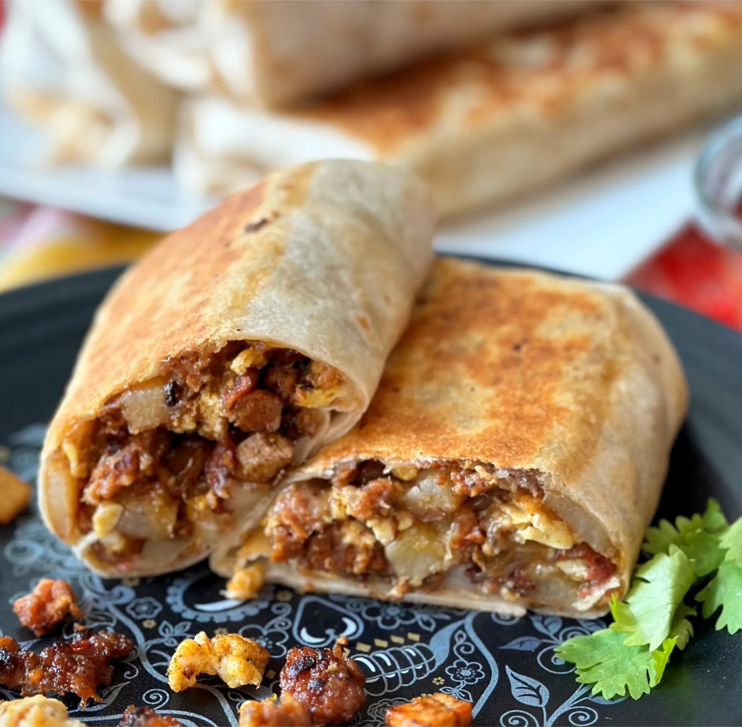 Breakfast burritos, sliced in half, on a plate.