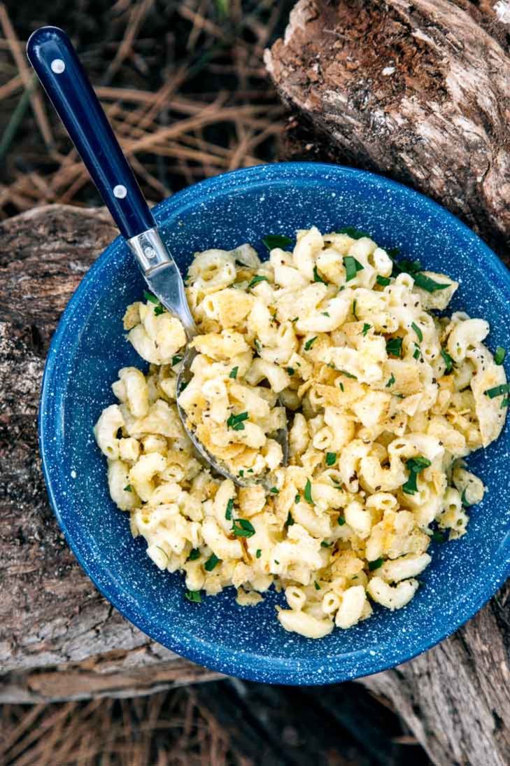 A blue camping bowl filled with mac and cheese