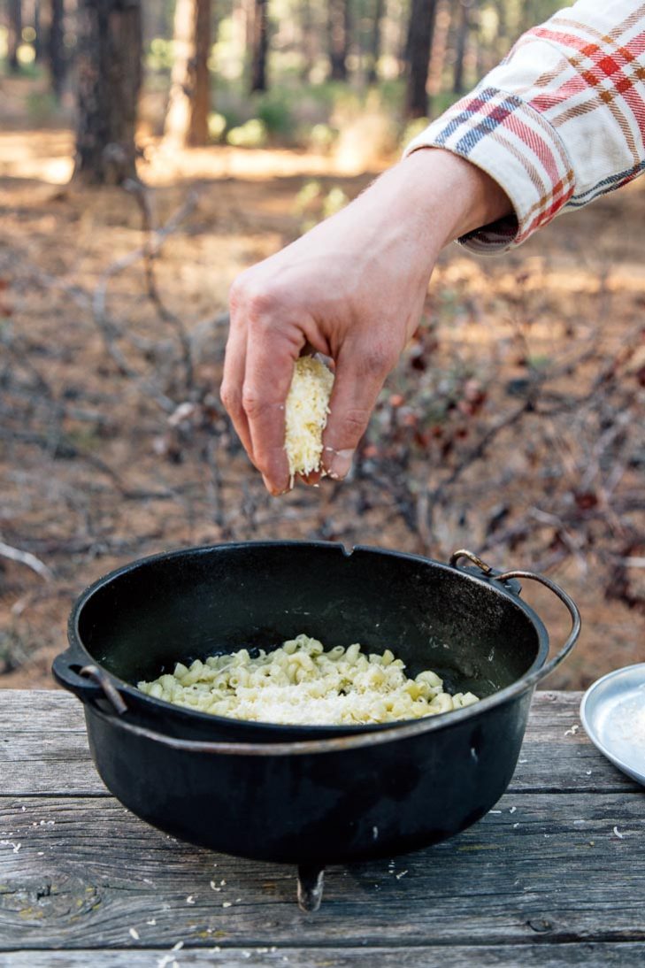 Sprinkling cheese into a Dutch oven