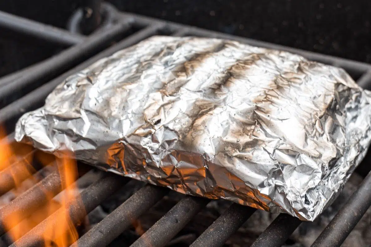 A foil packet on a campfire grill