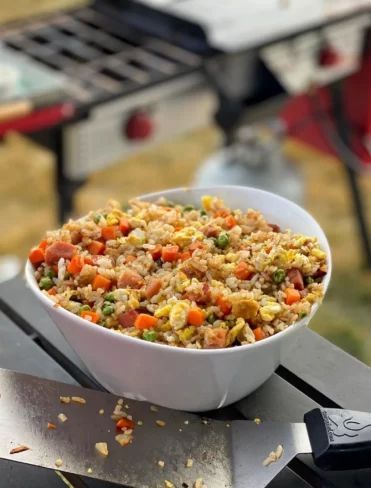 Fried rice in a bowl with a blackstone griddle in the background.