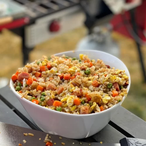 Fried rice in a bowl with a blackstone griddle in the background.