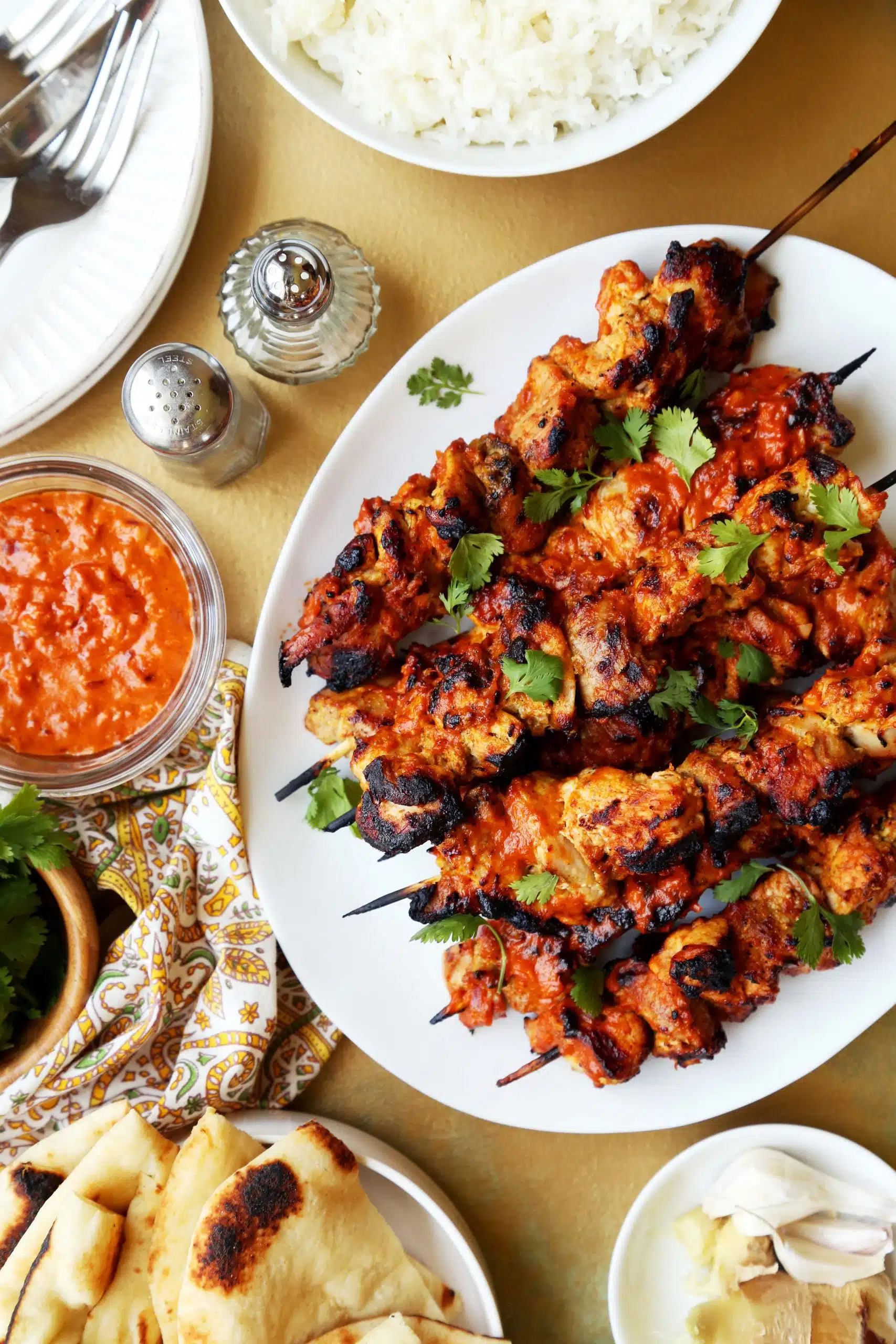 A platter of succulent grilled kebabs served with sides of naan bread, rice, and dipping sauce, ready for a flavorful feast.