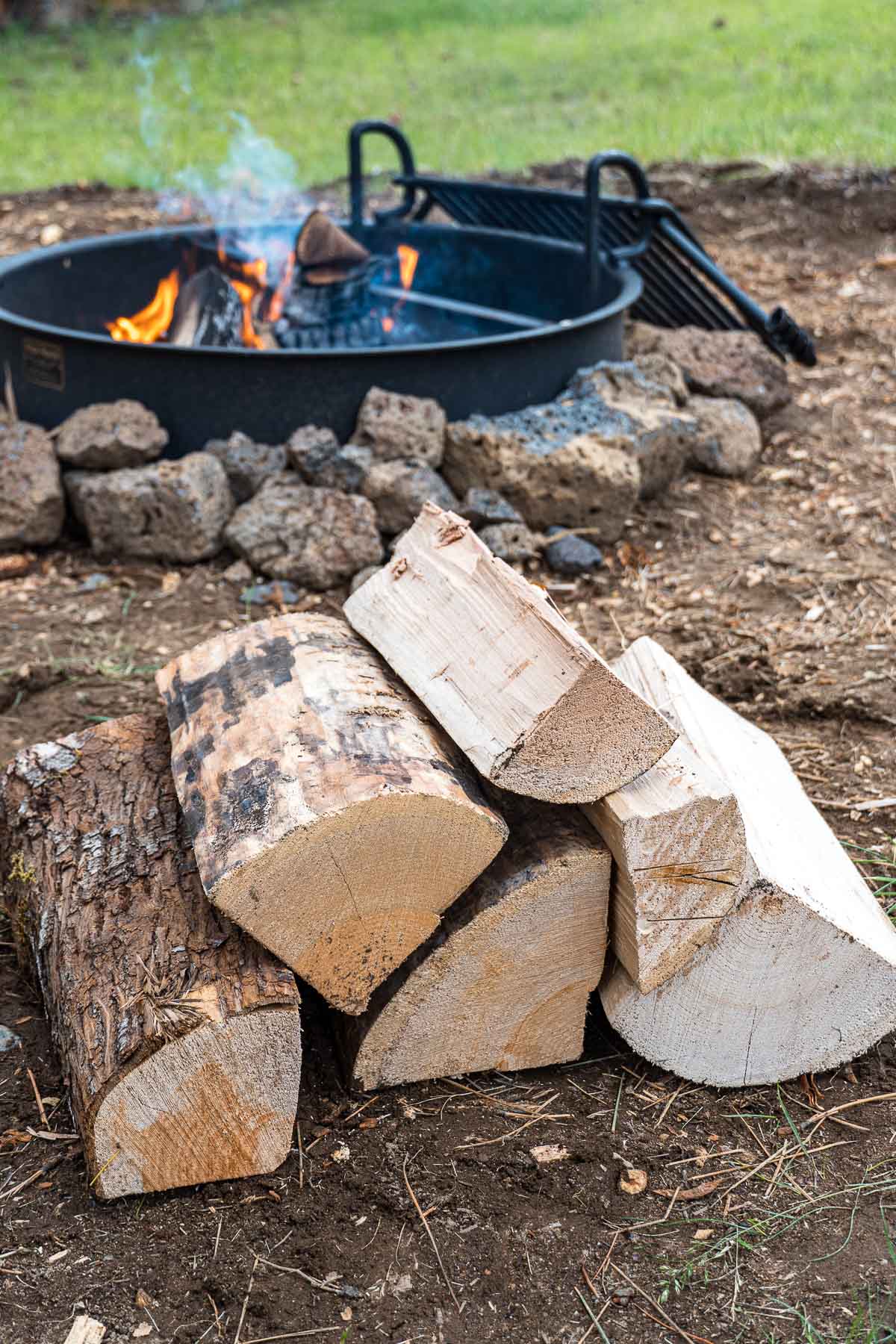A stack of firewood in front of a fire pit