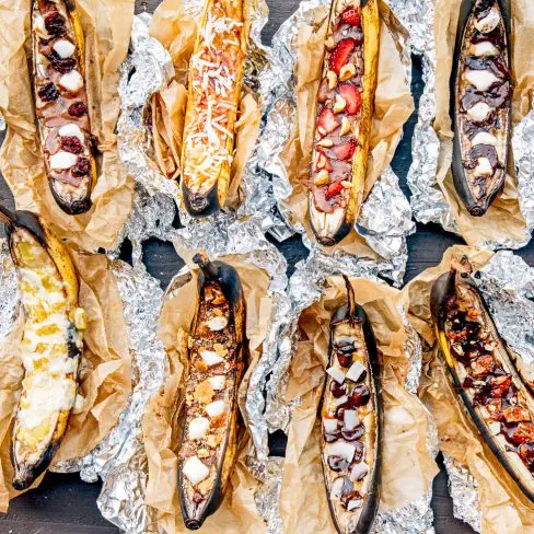 Banana boats in foil with a variety of toppings.