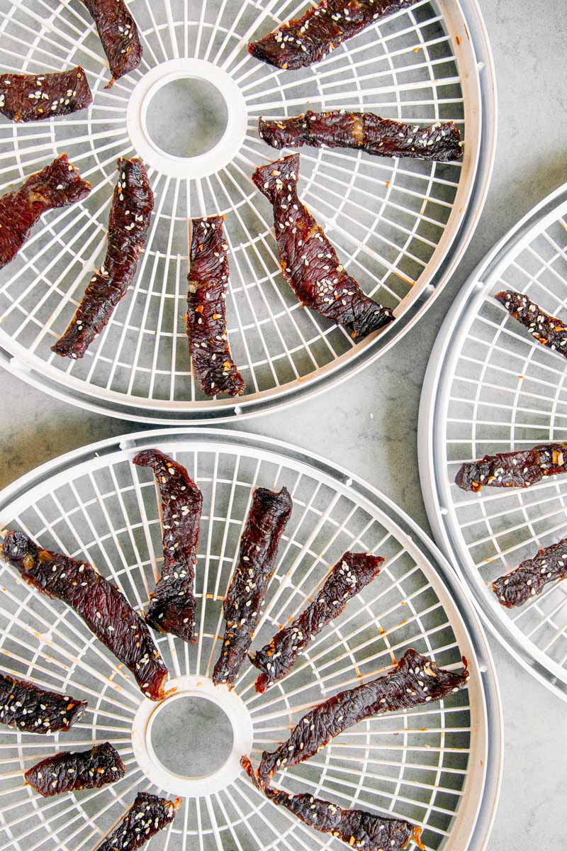 Overhead view of dehydrated beef jerky on trays.