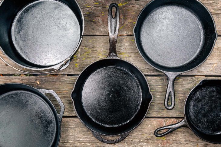 Cast iron skillets and Dutch oven on a wooden surface