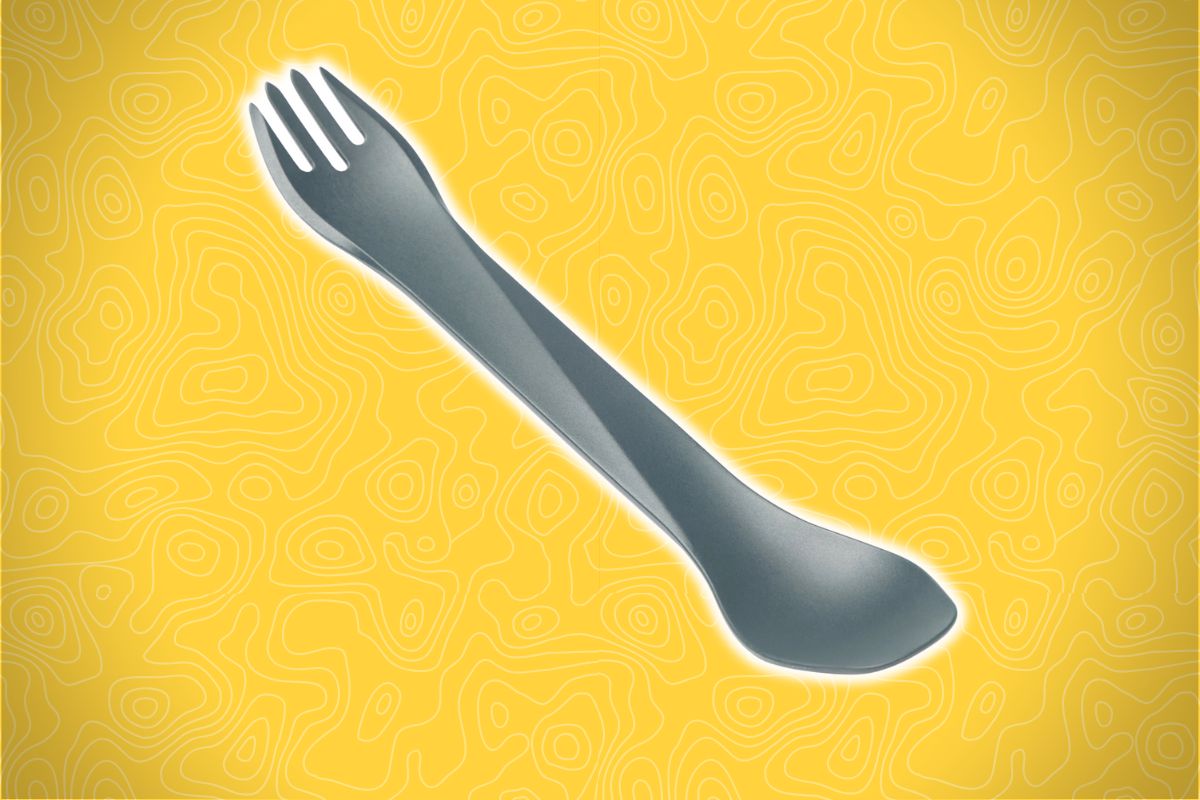 A gray spork lies diagonally on a yellow background with wavy abstract line patterns.
