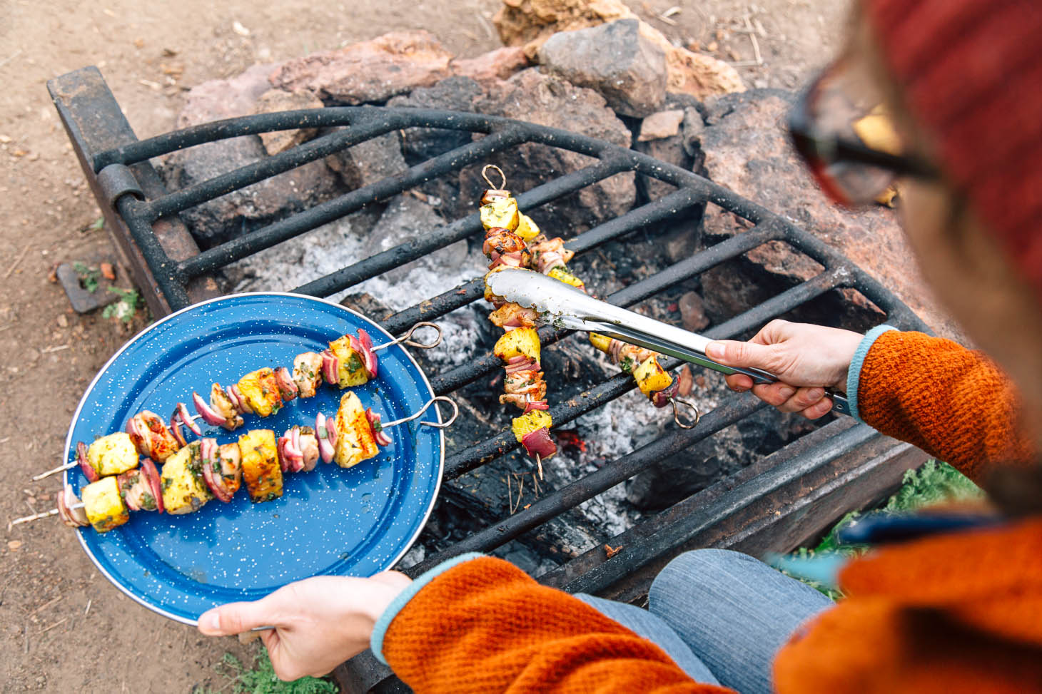 Grilling chicken pineapple kabobs over a campfire