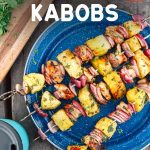 Pineapple Chicken Kabobs on a blue camping plate, text overlay reads "Grilled Pineapple & Chicken Kabobs"