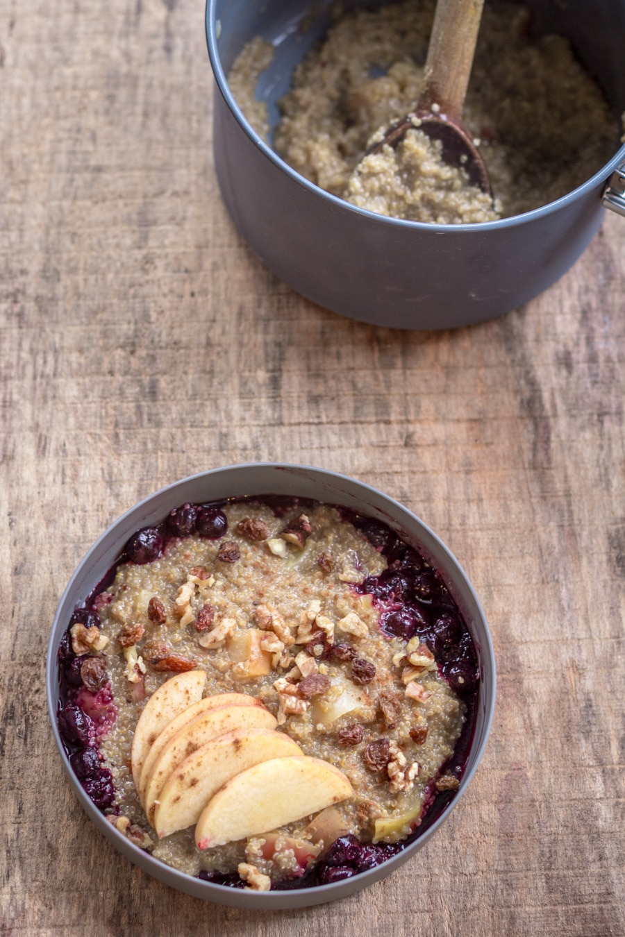 A bowl of quinoa porridge on a wooden surface.