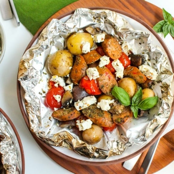 Sausages and vegetables topped with crumbled feta cheese.