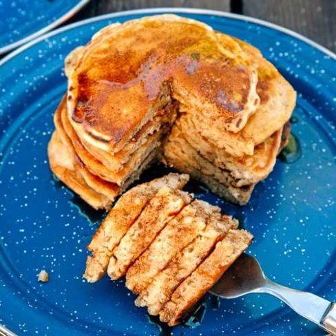 Pumpkin Spice Pancakes stacked on a plate with a bite taken out