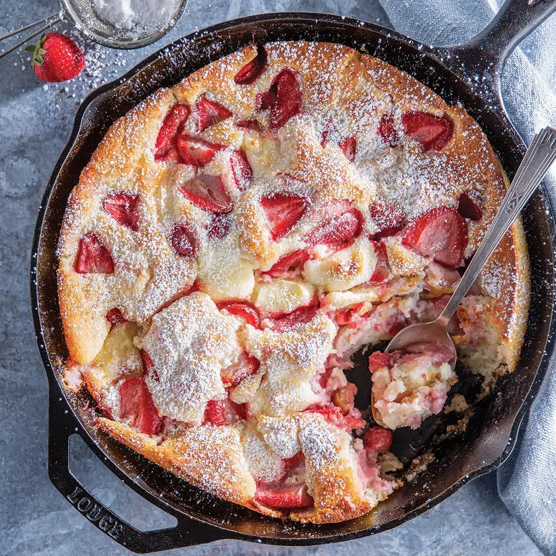 Strawberry cheesecake cobbler in a cast iron skillet.