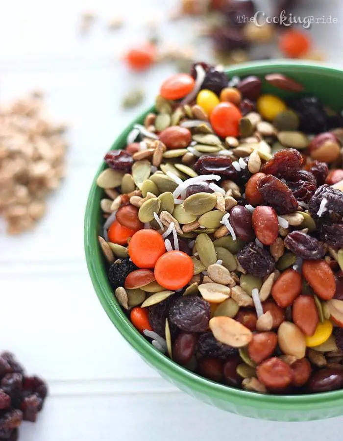Nut, seed, raisins, and candy pieces in a green bowl